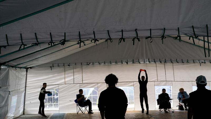 FILE - Ukrainian refugees play with frisbees as they wait in front of a gymnasium Tuesday,...
